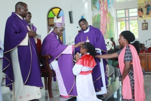 Askofu Msaidizi wa Jimbo Kuu Katoliki la Dar es Salaam, Mhashamu Henry Mchamungu akimpatia Sakramenti Takatifu ya Kipaimara mmoja wa vijana 72 katika Parokia ya Mtakatifu Maria Magdalena – Kimara Mtoni, jimboni humo, wakati wa Adhimisho la Misa Takatifu. Kushoto ni Paroko wa Parokia hiyo, Padri Victor Mwansa, na katikati ni Paroko Msaidizi, Padri Tatenda Kakwedza. (Picha na Mathayo Kijazi)